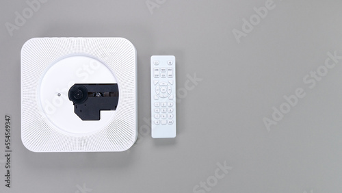 Stylish white portable compact CD player with controller on grey background. Retro vintage trending disc player. Top view, copy space, space for text. Hobby entertainment leisure