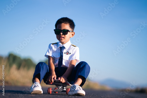 A dark-rimmed boy wearing a white aviator suit looks sharp in vintage tones