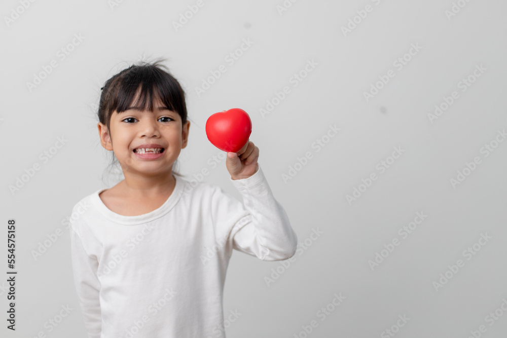 Portrait of Asian little girl child holding red heart sign on white background Portrait of Asian little girl child holding red heart sign on white background
