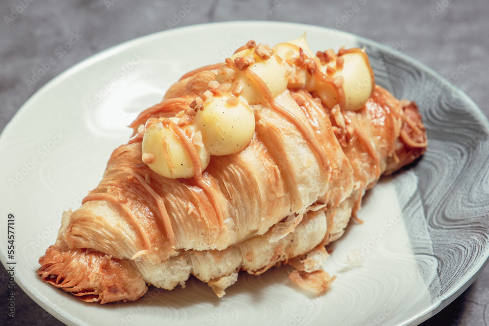French Pastry on a plate with concrete background. French Croissant, Cinammon Roll, Cruffin, Bread Stick, Scones. French Pastry on a plate with concrete background. French Croissant, Cinammon Roll, Cruffin, Bread Stick, Scones.