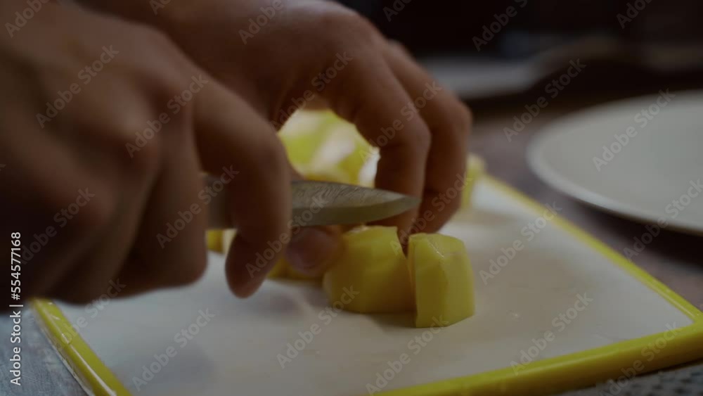 Hands close-up man prepares, father at home in kitchen. Cooking soup, lunch, dinner. Cutting vegetables, potatoes on board with knife. Surprise, helping your wife. Step by step recipe homemade dish. Hands close-up man prepares, father at home in kitchen. Cooking soup, lunch, dinner. Cutting vegetables, potatoes on board with knife. Surprise, helping your wife. Step by step recipe homemade dish.