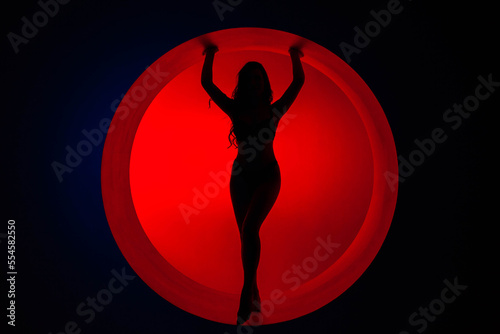 Silhouette of a young girl in red fill with beautiful legs and arms