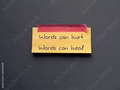 Yellow note stick on blue background with text Words can hurt Words can heal - to remind language have power to harm or heal - word choice matters most so choose wisely