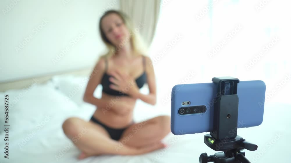 Young woman in lingerie posing in front of camera and working as a sexy model