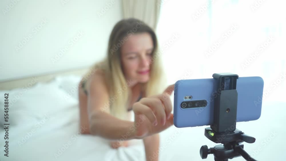 Young woman in lingerie posing in front of camera and working as a sexy model