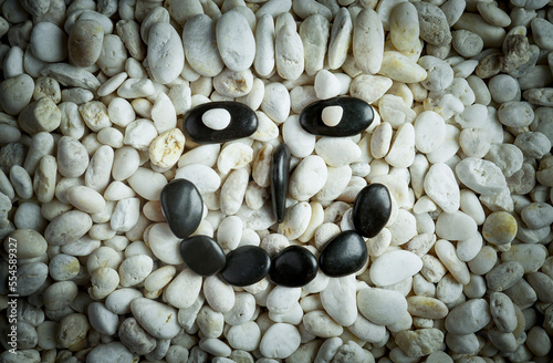 Stone faces small black and white stones with sad happy and angry faces photo