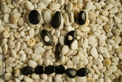 Stone faces small black and white stones with sad happy and angry faces photo