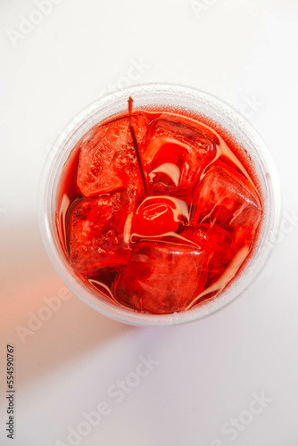 Red cherry lemonade with ice and cherries on a white background. view from above