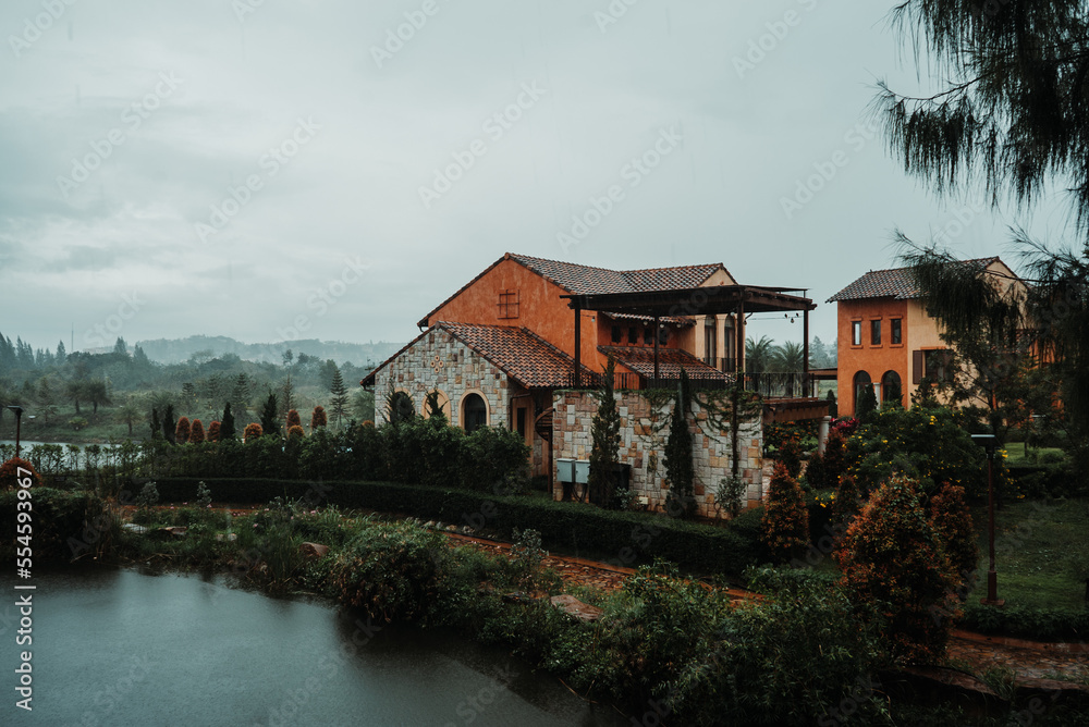 Fototapeta premium Old house by the river surrounded by mountains