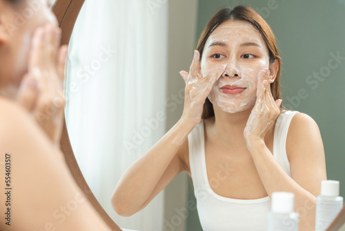 Cheerful asian young woman  beauty girl hand applying foam cleanser for washing on her face  clean fresh healthy skin care  exfoliation scrub soap with cleansing product. Skincare spa relax concept.
