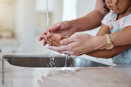 Child, washing hands and learning about healthy lifestyle with clean water for health and wellness of body with mother at family home. Hand hygiene with woman and girl kid to clean dirt and bacteria photo