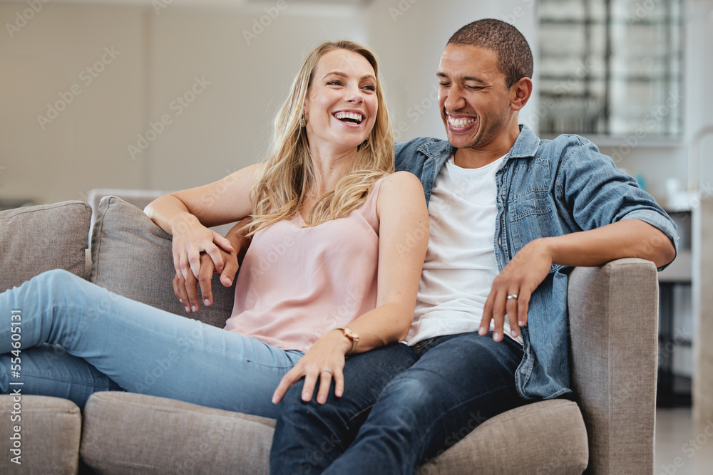 © Delcio F/peopleimages.com - Relax, funny or couple of friends love laughing at joke, story or gossip for entertainment on sofa at home. Interracial, comic or happy woman enjoying quality bonding time and holding hands with man