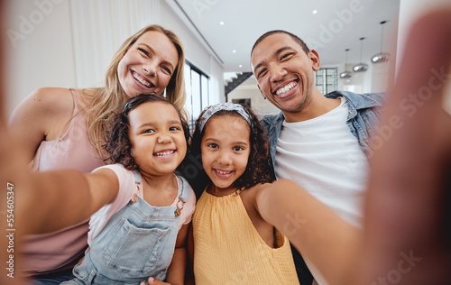 Family selfie  bonding and children with parents  cheerful and playful smile on the living room sofa. Quality time  happy photo and girl kids with interracial mother and father for a home memory