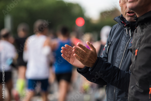 Close-up photo, detail of person applauding and cheering the marathon runners. © JoseManuel