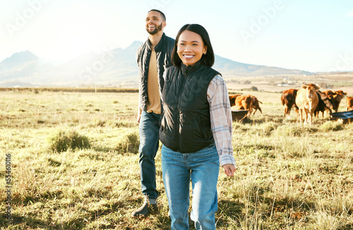 Farm, agriculture and cattle with a couple walking on a field or meadow together for beef of dairy farming. Cow, sustainability and teamwork with a man and woman farmer bonding while working outdoor