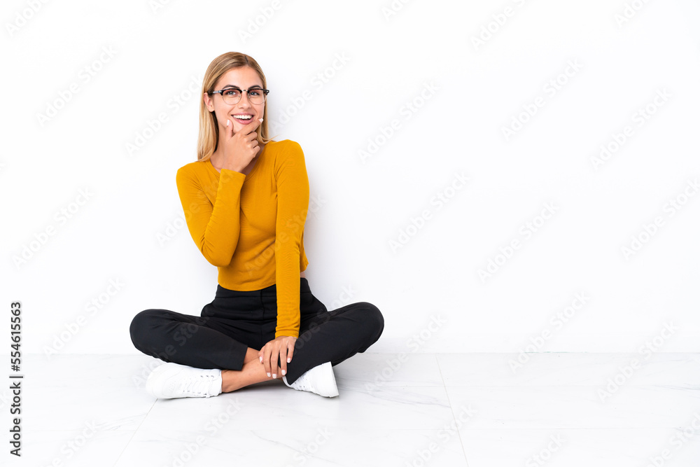 Fototapeta premium Blonde Uruguayan girl sitting on the floor smiling