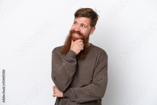 Redhead man with beard isolated on white background looking to the side and smiling © luismolinero