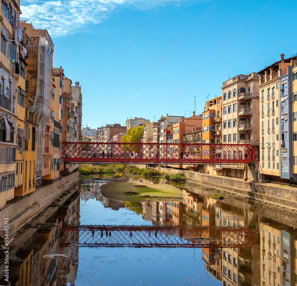 Girona,  colored houses and red touristic bridge in Spain