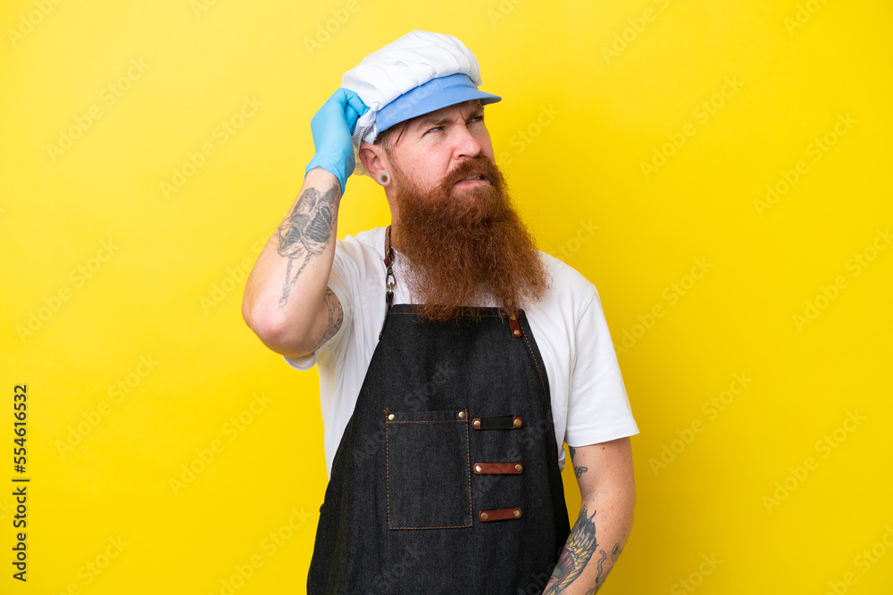 Fishmonger wearing an apron isolated on yellow background having doubts and with confuse face expression