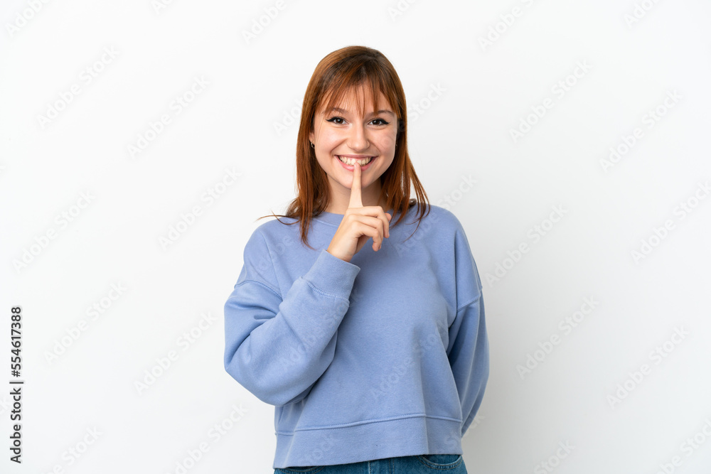 Redhead girl isolated on white background showing a sign of silence gesture putting finger in mouth Redhead girl isolated on white background showing a sign of silence gesture putting finger in mouth