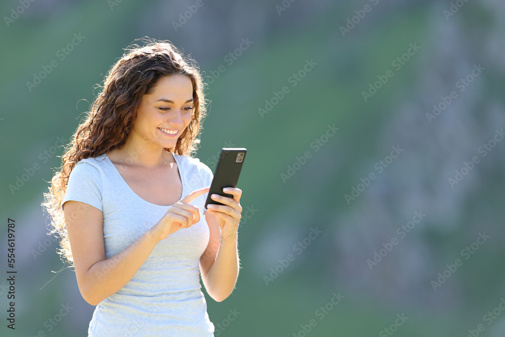 Happy woman in the mountain using cellphone Happy woman in the mountain using cellphone