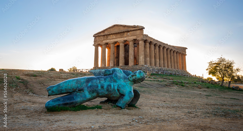 Temple of Concordia and the statue of Fallen Icarus, in the Valley of the Temples, Agrigento, Sicily, Italy - obrazy, fototapety, plakaty 