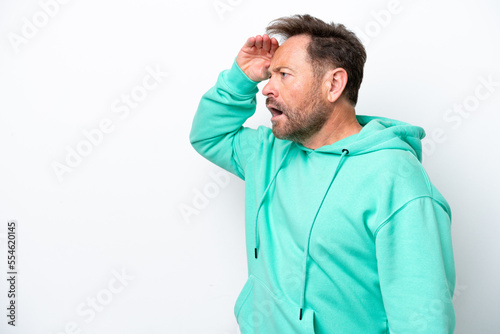 Middle age caucasian man isolated on white background with surprise expression while looking side