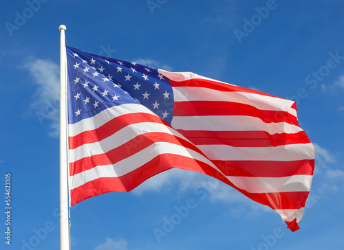 american flag with stars and stripes flying in the blue sky photo