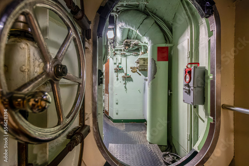 Inside a submarine with a metal door and different technical facilities photo