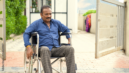 Canvas Print Lonely Indian senior, elder, widower living with disability, rolling wheelchair outside old age home