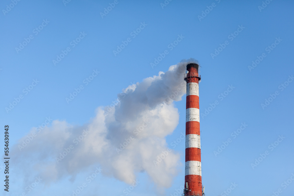 White thick smoke from the boiler room chimney. Smoke against the blue sky. Air pollution. Heating of the city. Industrial zone. White thick smoke from the boiler room chimney. Smoke against the blue sky. Air pollution. Heating of the city. Industrial zone.