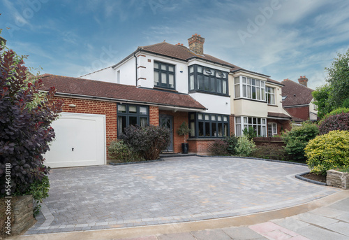 Typical semi-detached house in South East England, UK with anthracite grey windows and block paving drive.