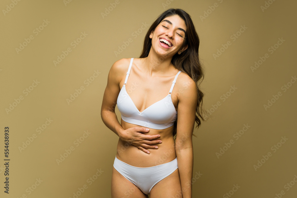 Excited young woman smiling relaxing in underwear Excited young woman smiling relaxing in underwear