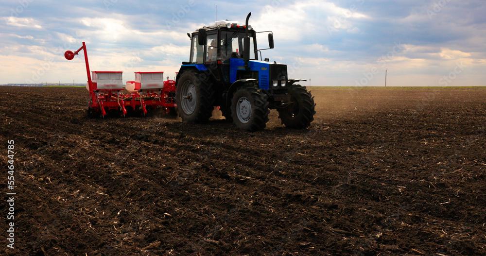 Fototapeta premium Agriculture. Tractor, Seeding Machine Working in Field on a Farm. Seeder, Planter Combine. Tillage, Plowing. Agricultural Equipment. Season Sowing Grain. Spring time Process Planting Seeds.