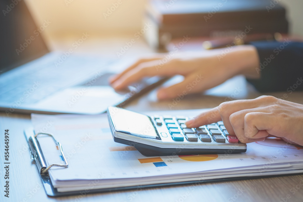 Marketing, Finance, Accounting, Planning, Team female accountant using laptop calculator and documents, charts, graphs in the analysis of the company is profit. Marketing, Finance, Accounting, Planning, Team female accountant using laptop calculator and documents, charts, graphs in the analysis of the company is profit.
