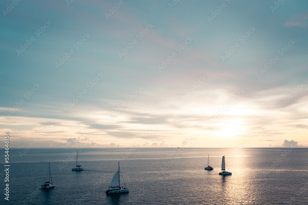 Golden sunset shine over the sea with sailboats