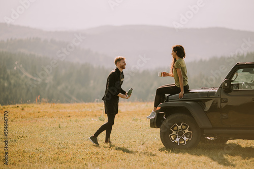 Young couple relaxing on a terrain vehicle hood at countryside