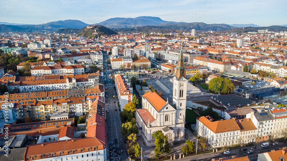 Aerial view of Graz city in the austrian region Styria with a church in the foreground and the inner city with the Schloßberg landmark in the background