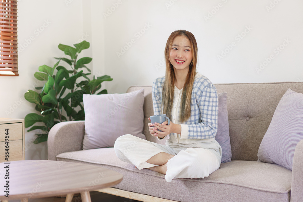 Leisure time concept, Women holding coffee cup and sitting on the couch to spending relax time Leisure time concept, Women holding coffee cup and sitting on the couch to spending relax time