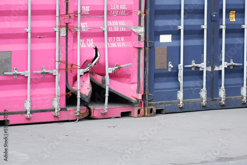 Shipping containers are stacked at the port. one of them is damaged