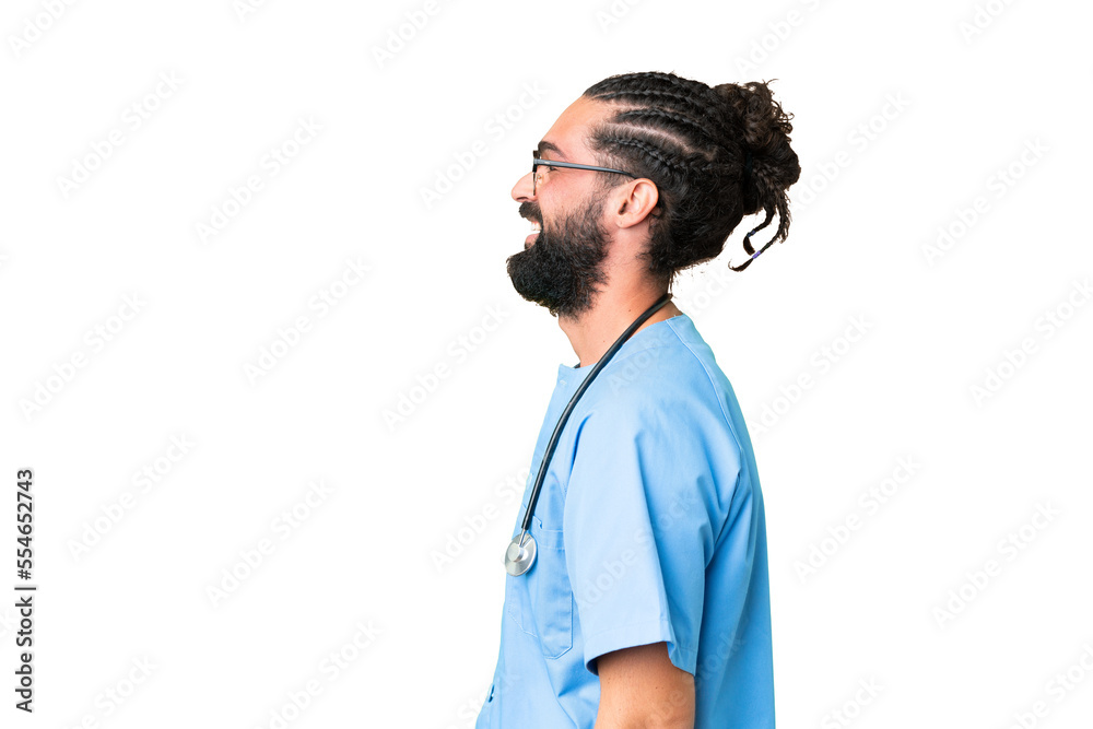 Young doctor man over isolated chroma key background laughing in lateral position Young doctor man over isolated chroma key background laughing in lateral position