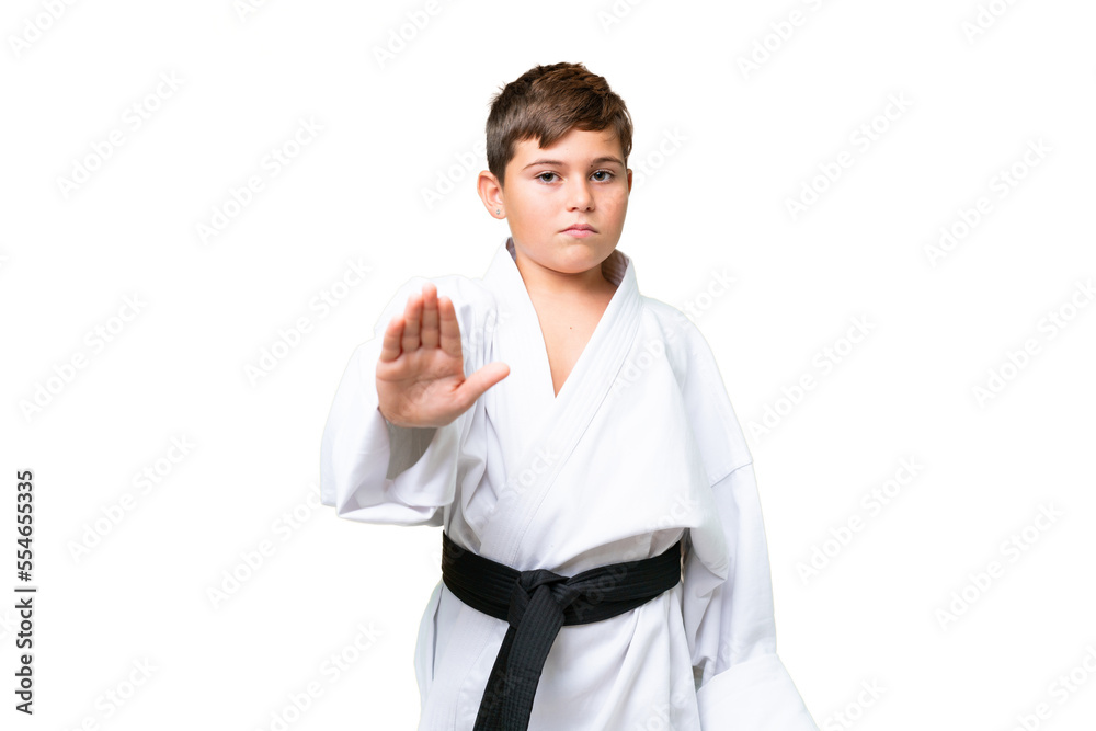 Little caucasian kid doing karate over isolated chroma key background making stop gesture Little caucasian kid doing karate over isolated chroma key background making stop gesture