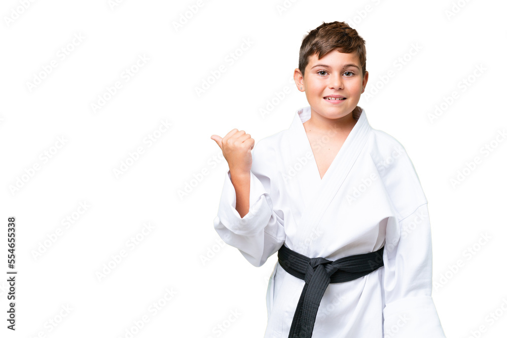 Little caucasian kid doing karate over isolated chroma key background pointing to the side to present a product Little caucasian kid doing karate over isolated chroma key background pointing to the side to present a product