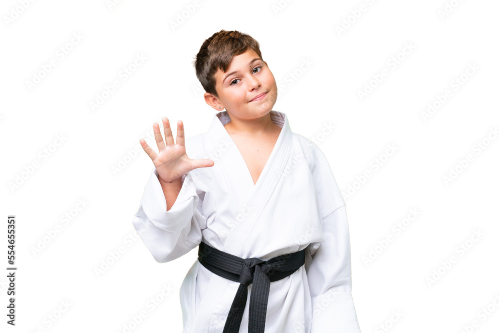 Little caucasian kid doing karate over isolated chroma key background counting five with fingers Little caucasian kid doing karate over isolated chroma key background counting five with fingers