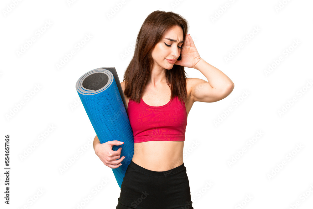 Young sport caucasian woman going to yoga classes while holding a mat over isolated chroma key background with headache