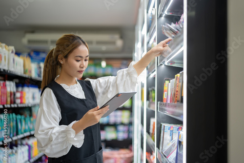 Canvas Print supermarket clerk using apps on a digital tablet, innovative technology, and work concept, and a young female supervisor with a tablet pc in the mall