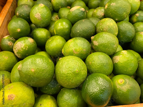 close up view of fresh and healthy lime on the market rack. selective focus of citrus background