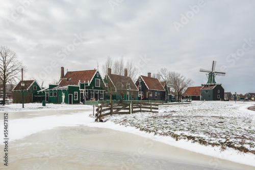 Winter landscape with frozen canal and traditional wooden house in Zaanse Schans, Netherlands