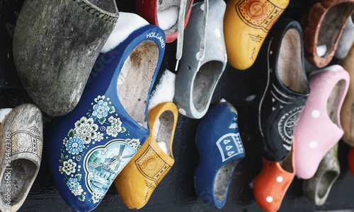 Colorful clogs against the background of a wooden wall.