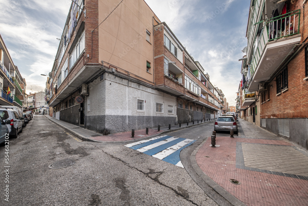 Facades of urban buildings at a crossroads with zebra crossings